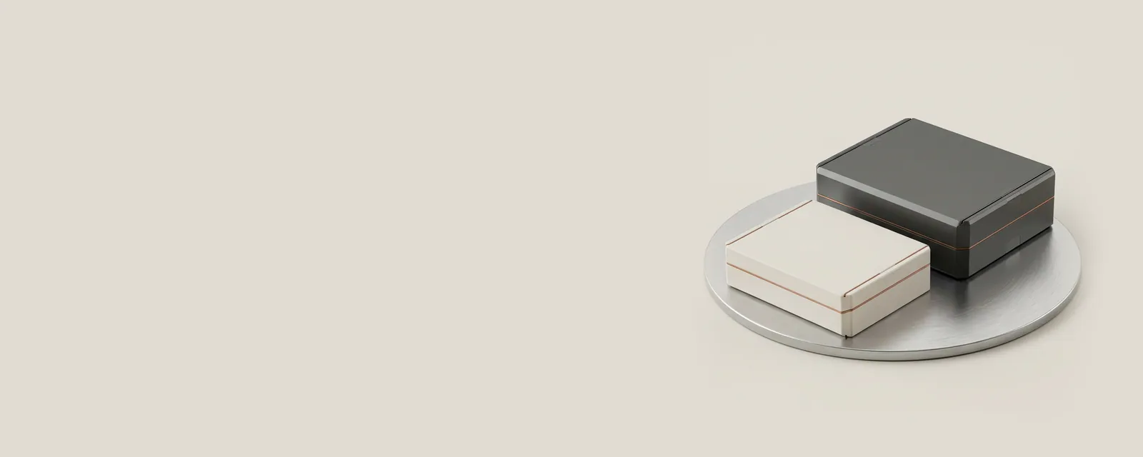 Studio render of two sealed matte package boxes on a rotating aluminium stage, the front box being set aside as the rear one returns