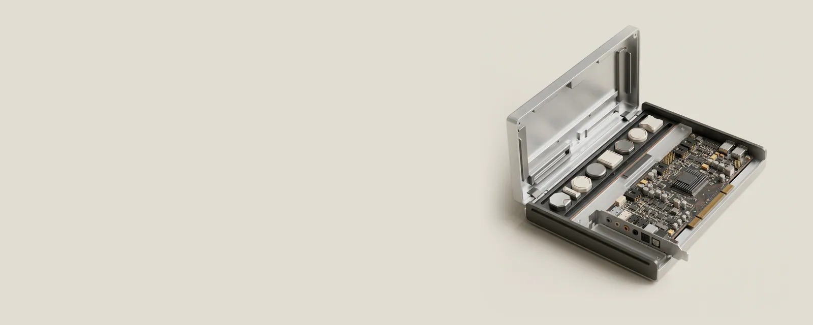 Studio render of an open aluminium case revealing small machined file tokens of different shapes lined up beside a sound card