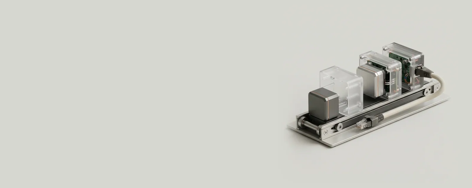 Studio render of small machined blocks being nested inside larger frosted acrylic cases on a slim conveyor toward an Ethernet cable
