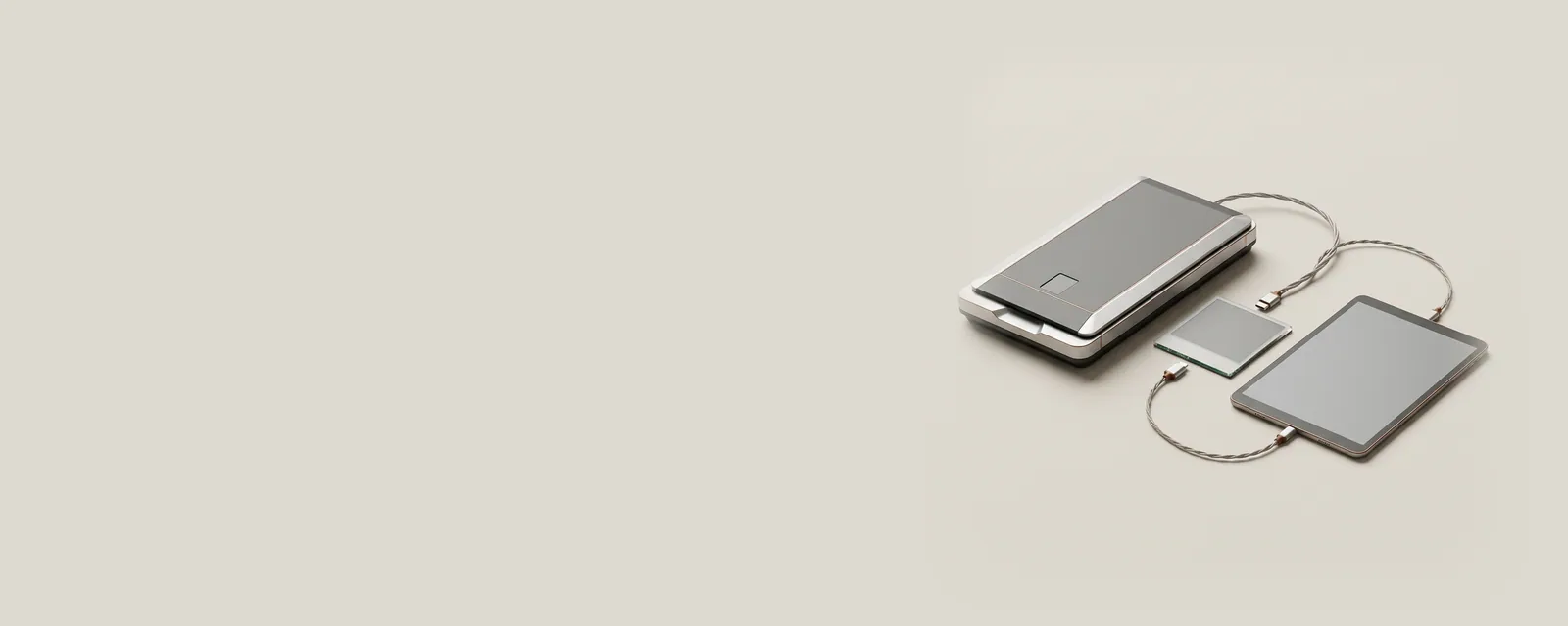 Studio render of a scanner and a tablet showing a plain grey surface, joined by a twisted pair of fine braided cables, a photo tile between them