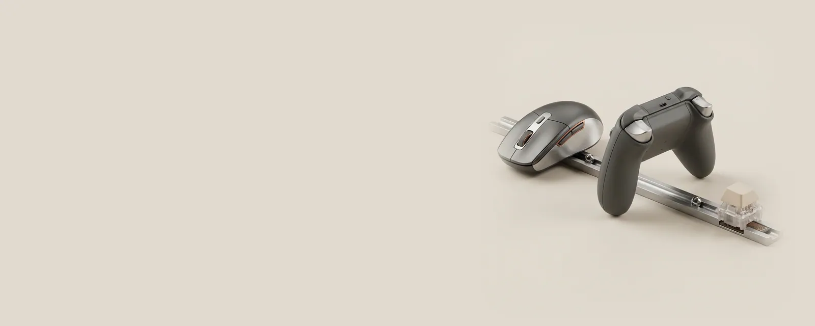 Studio render of a mouse, a gamepad and a single keyboard switch each sending a steel bead along one shared machined rail